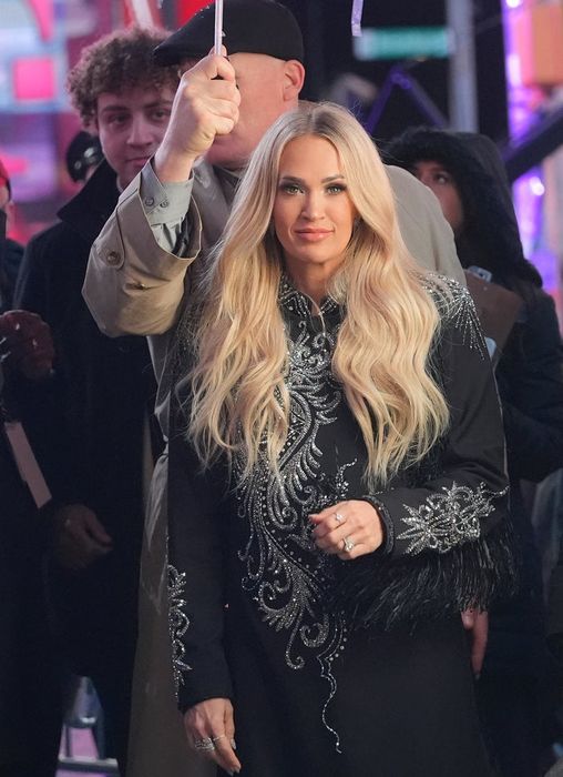 Carrie poses in a stunningly embroidered dress on the red carpet, beaming among the crowd.