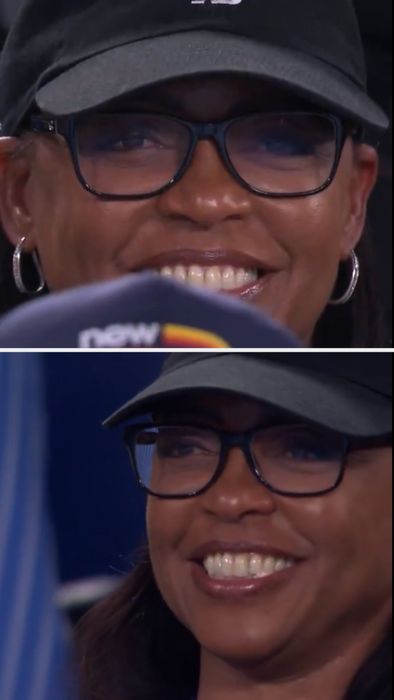 Candi grinned, wearing glasses and a baseball cap.