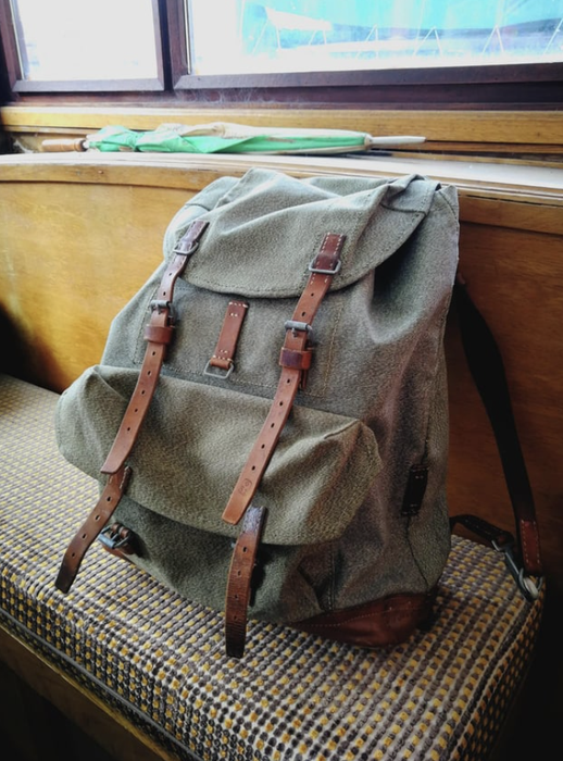 A backpack resting on a couch with straps attached.