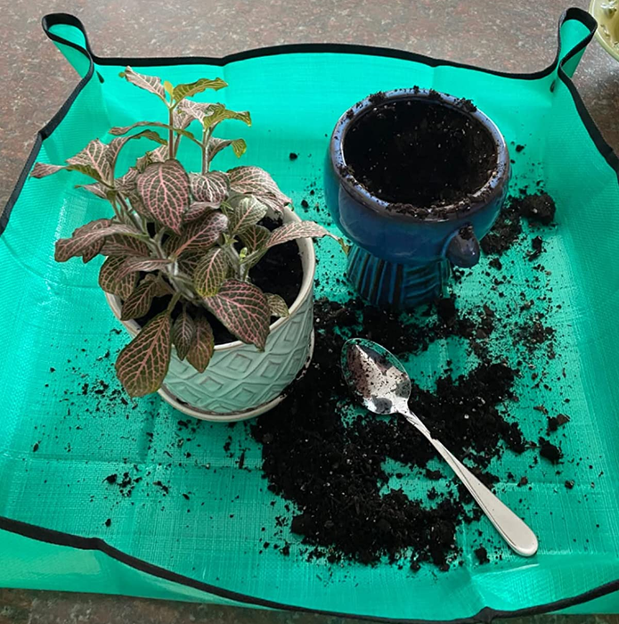 A reviewer's photo of a gardening mat with pots and soil.