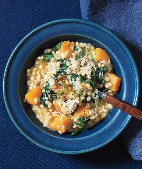 A blue bowl filled with Baked Barley Risotto featuring roasted butternut squash.