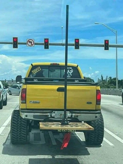 A lifted truck with a pole mounted on a wooden platform in the back, featuring a 