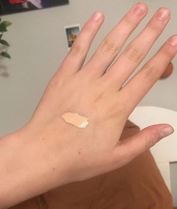 A hand showing a swatch of the concealer on the back