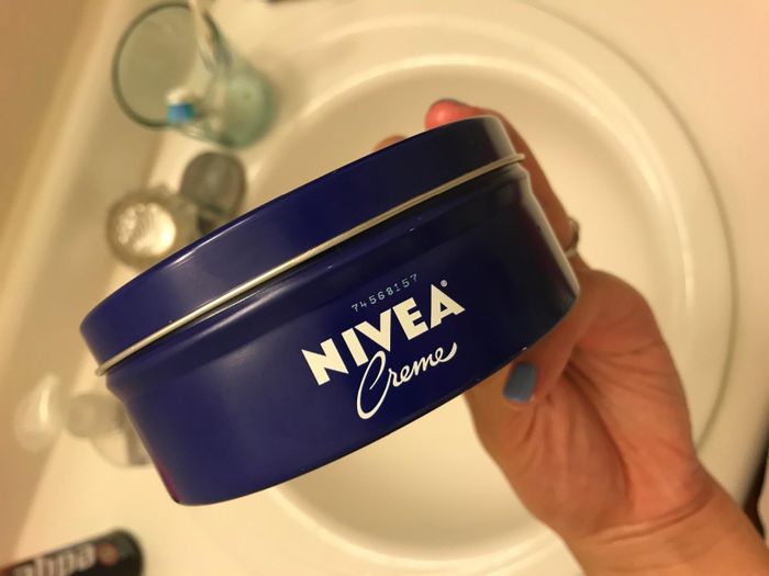 image showing a reviewer holding the tin of the Nivea face and body cream