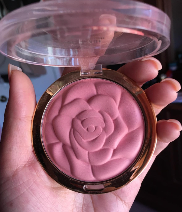 The reviewer holding a rose-shaped powder blush