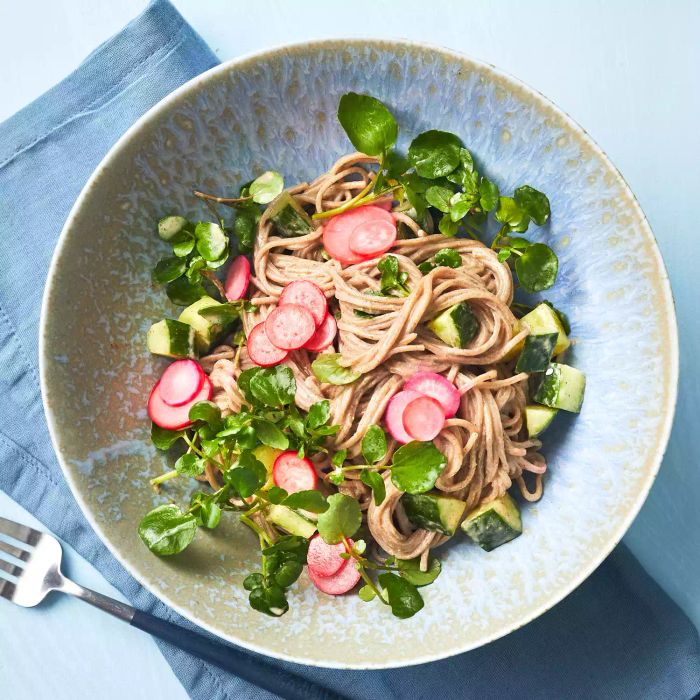 Quick nutty noodles with radishes and cucumbers, served in a large bowl with a metal fork on the side