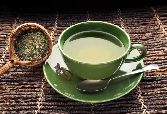 A green mug filled with freshly brewed green tea