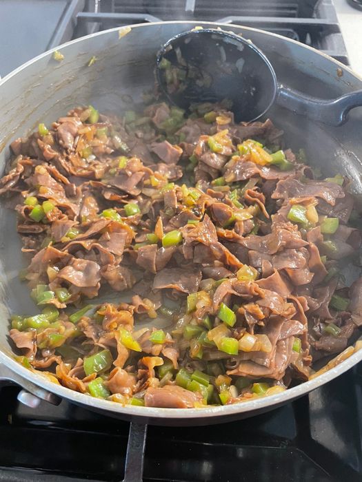 Meat and vegetables cooking in a pan.