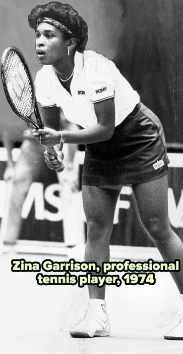 A tennis player, outfitted in a Pony sports ensemble, gets ready for a match while gripping a racket.