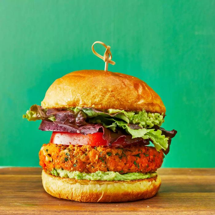 A Chickpea Veggie Burger resting on a wooden cutting board, ready for serving