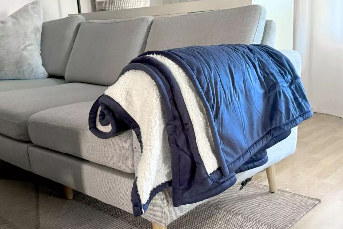 A Sunbeam Royal Mink Sherpa Heated Blanket elegantly placed on a sofa