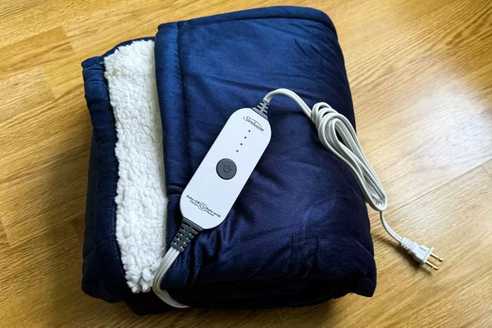 The Sunbeam Royal Mink Sherpa Heated Blanket neatly folded on a wooden floor