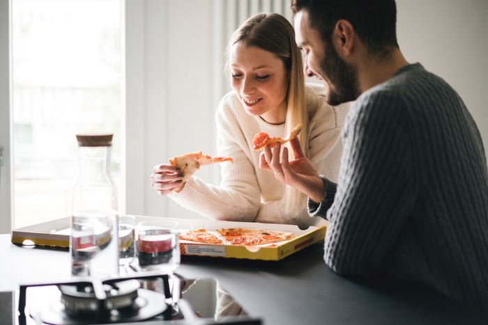 a couple enjoying takeout pizza