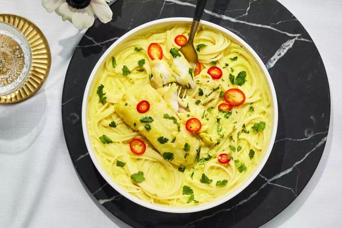 A soothing bowl of coconut broth with tender cod and noodles