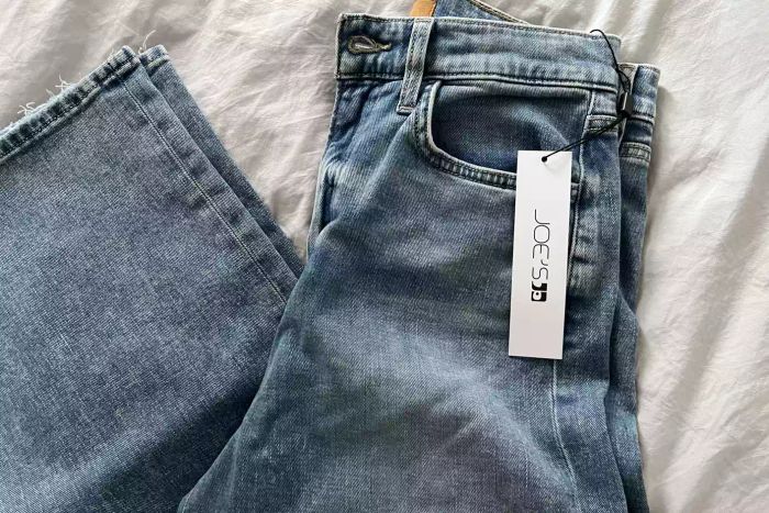 Joe's Jeans The Mia High-Rise Wide Leg Jean neatly folded atop a sheet.
