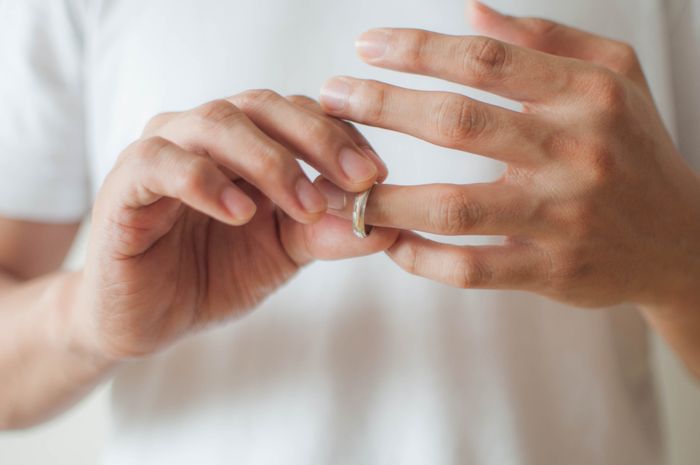 A person removing their wedding ring.