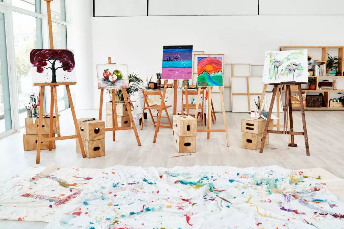 A close-up of a painted canvas on easels in an empty studio after an art class, captured during the day.