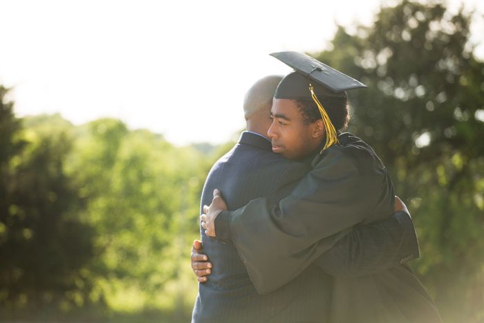 a graduate hugging an older man