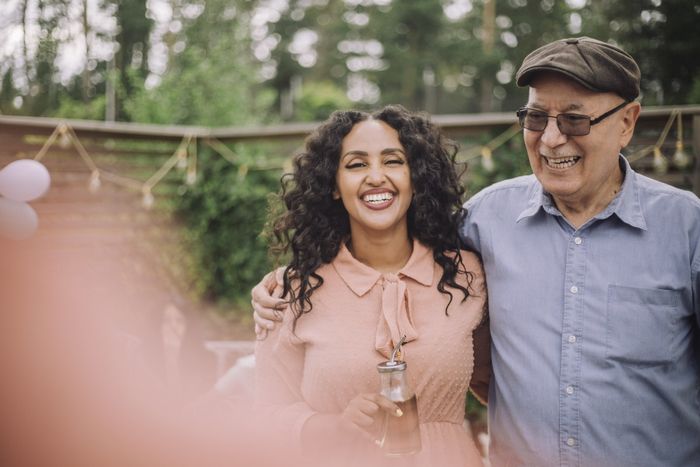 an elderly man and a young woman smiling together
