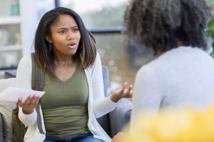 a teenage girl looking shocked and speaking to a woman