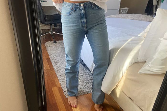 Person standing in a bedroom wearing Madewell The ’90s Straight Jean