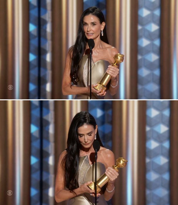Demi, dressed in an elegant gown, holding her trophy while speaking into a microphone.
