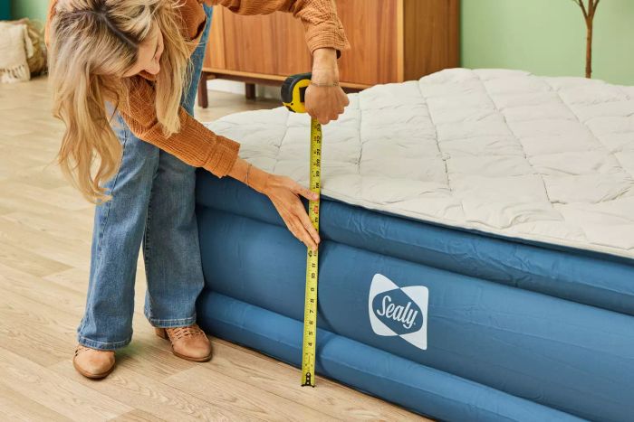 A person checks the height of the Sealy AlwayzAire Flocked Top Air Mattress