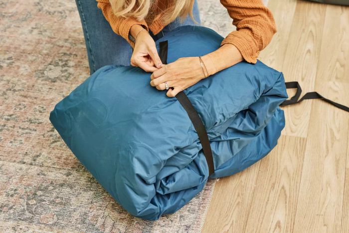 A person fastens the strap on the Sealy AlwayzAire Flocked Top Air Mattress