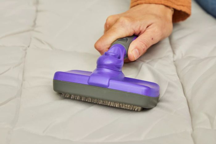 A person examines the fabric on the surface of the Sealy AlwayzAire Flocked Top Air Mattress.