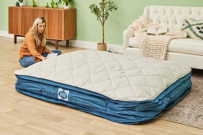 A person inflates the Sealy AlwayzAire Flocked Top Air Mattress