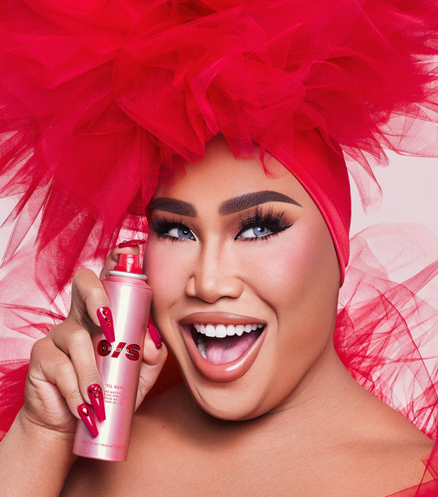Patrick Starr holding a pink setting spray bottle