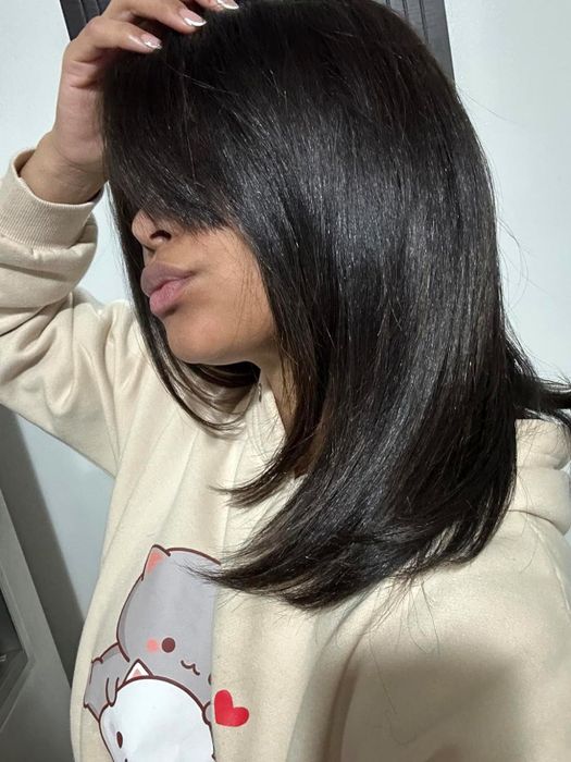 A reviewer proudly showing off the glossy shine the product gave their hair