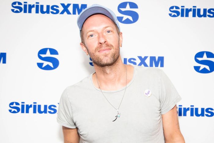 A man in a casual shirt and cap stands in front of a SiriusXM backdrop