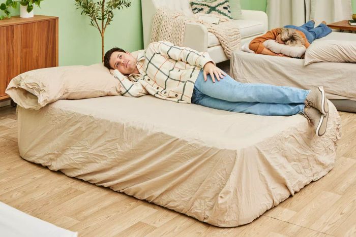 A person is lying on the SereneLife Luxury Full-Size Air Mattress with Built-in High-Speed Pump.