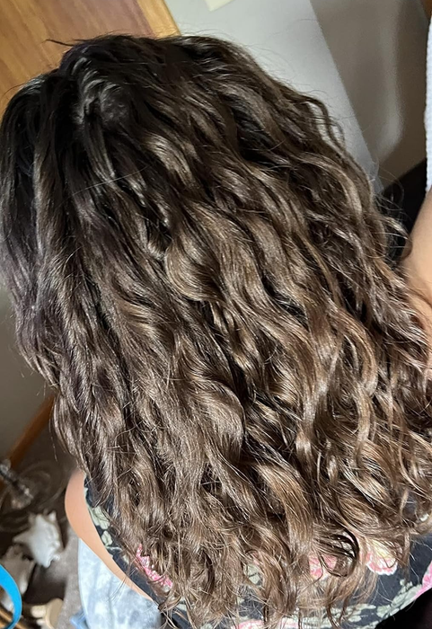 A reviewer from behind, showing off their wavy hair