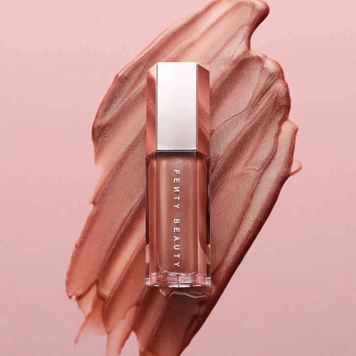 A smear of creamy Fenty Beauty lipstick in the background, showcasing the product for purchasing purposes.