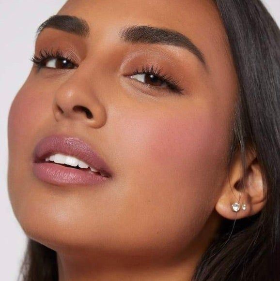 A close-up of a model showcasing the blush applied to their cheeks.