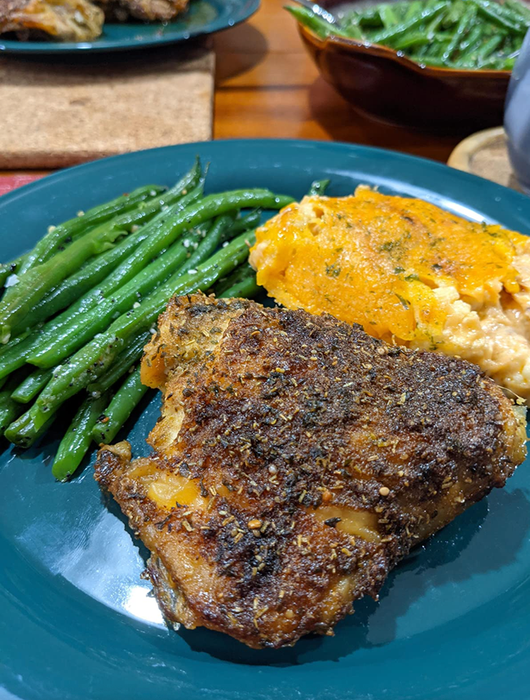 The seasoning sprinkled on a delicious steak alongside mashed potatoes and green beans.