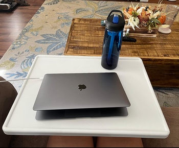 The white tray table placed over a reviewer’s legs.