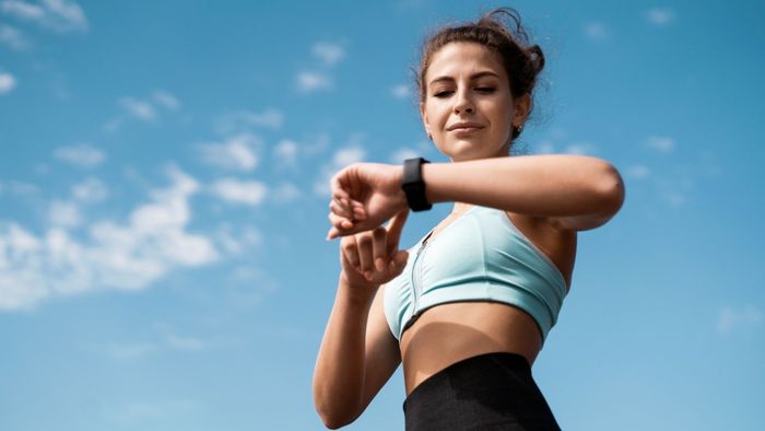 woman outdoors monitoring her fitness tracker