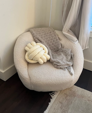 A white version of the pillow sitting atop a chair.