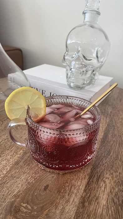 A glass mug featuring a subtle dot sunflower print, filled with refreshing iced tea.
