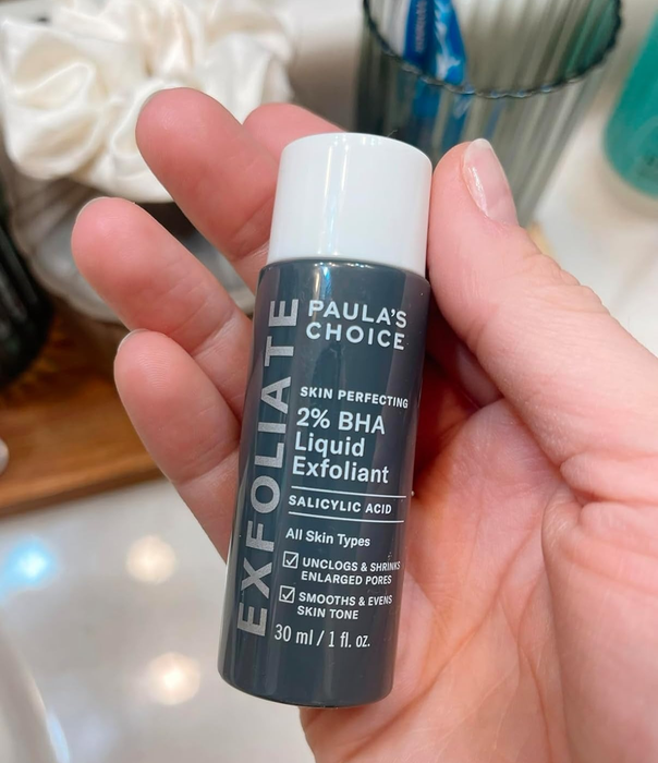 A reviewer holding the bottle of Paula's Choice Skin Perfecting 2% BHA Liquid Exfoliant