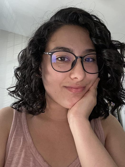 A reviewer flaunting their shiny, curly hair after using the product