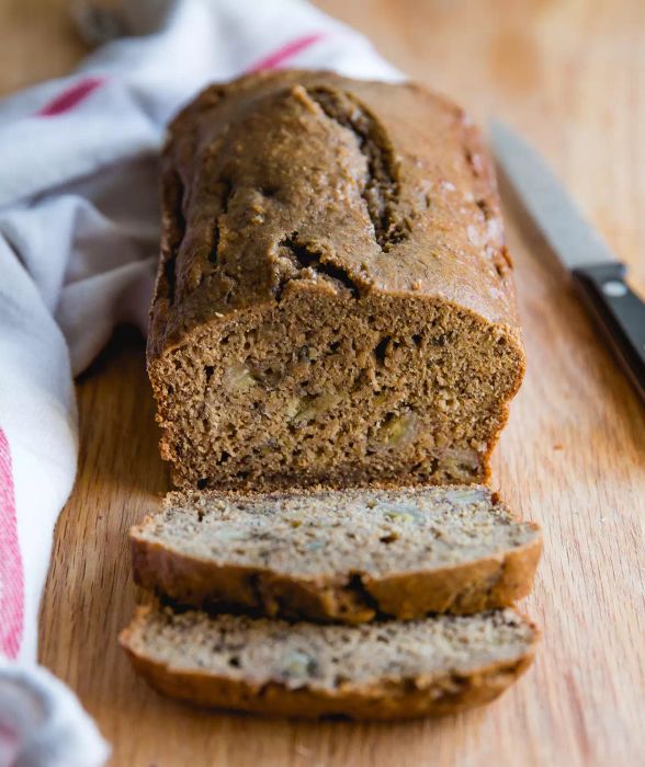 Banana Bread on Wooden Cutting Board with One Slice Cut