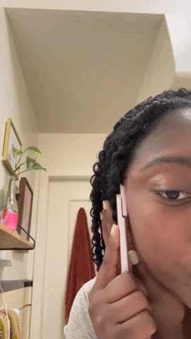 A gif of Amanda using the Solawave wand to target her cheeks.