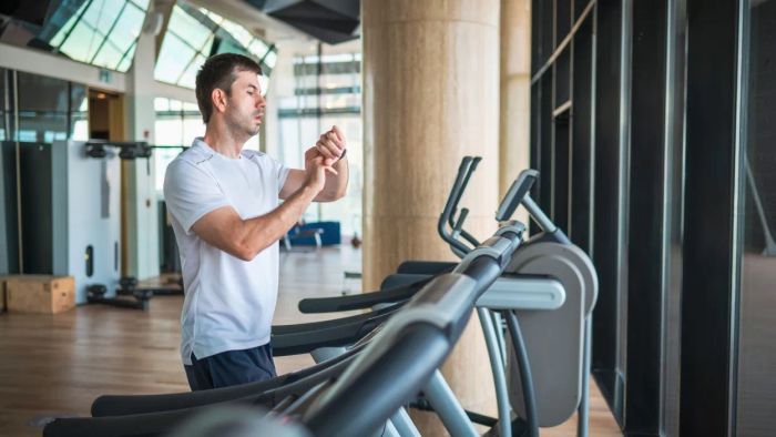 man running on treadmill wearing a smartwatch