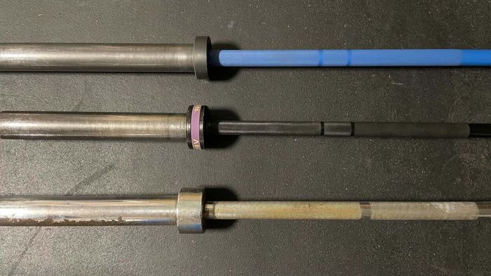 a lineup of three barbells side by side, each displaying its smooth metal rings