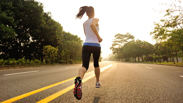 female runner sprinting down an empty street
