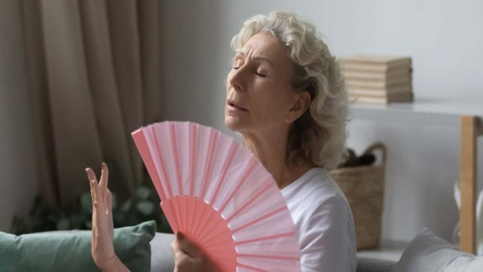 individual using a fan to cool off